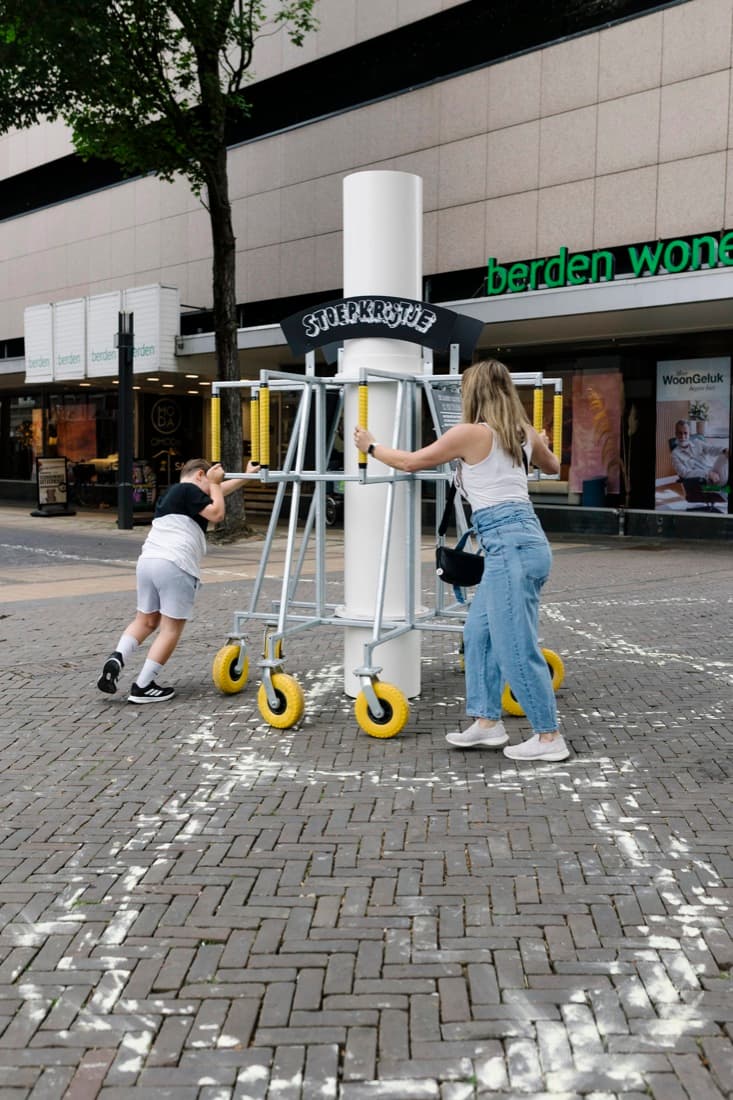 Kinderen spelen bij een kunstwerk in het centrum