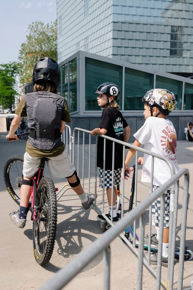 Kinderen met fietshelmen bij een hek